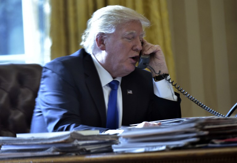 US President Donald Trump speaks on the phone with Russia's President Vladimir Putin from the Oval Office of the White House on January 28, 2017, in Washington, DC. Mandel Ngan/AFP 