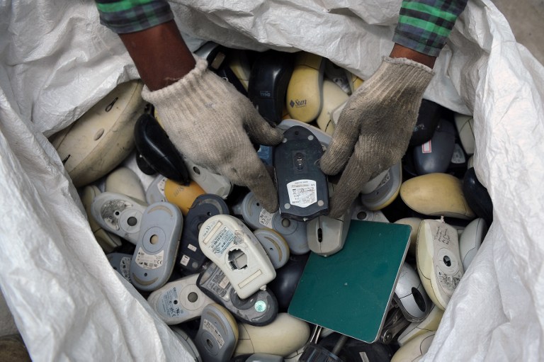 In this file photo, an Indian worker sifts through a bag full of defunct computer mice prior to disassembly at Ash Recyclers, a government approved e-waste management firm in Bangalore on June 5, 2013. Manjunath Kiran/AFP