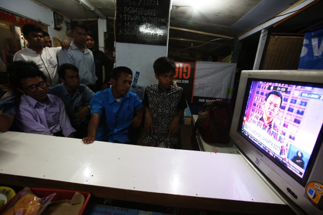 NOBAR. Warga menonton debat calon gubernur dan calon wakil gubernur DKI Jakarta yang disiarkan langsung stasiun televisi di salah satu warung di Senayan, Jakarta, Jumat, 13 Januari. Foto oleh Rivan Awal Lingga/ANTARA 